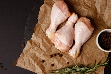 Siyah arka planda çiğ tavuk budu.