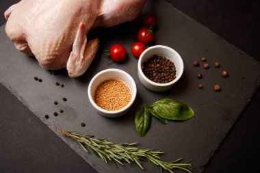 Siyah arka planda çiğ tavuk budu.