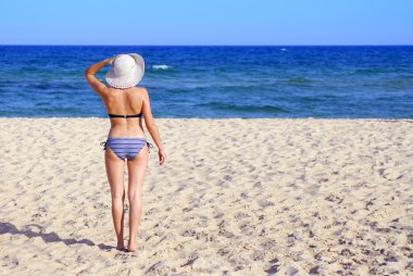 Sahilde beyaz şapkalı kadın