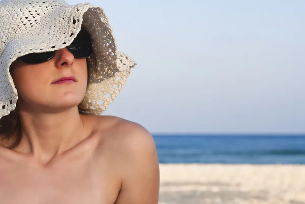 Žena na pláži s bílým kloboukem — Stock fotografie