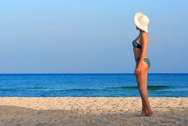 Žena na pláži s bílým kloboukem — Stock fotografie