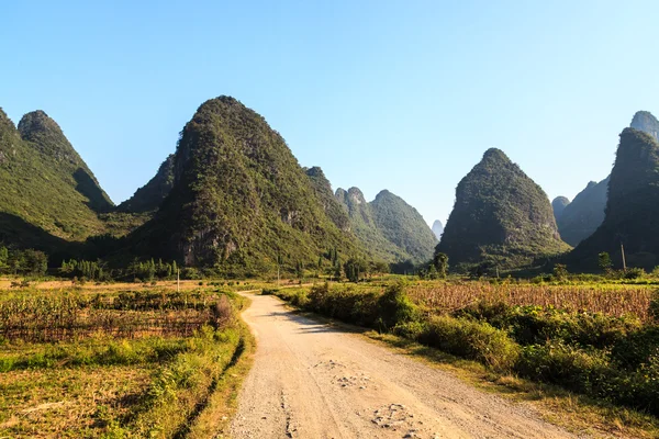 Sand road through a valley with limestone rocks — Stock Photo, Image