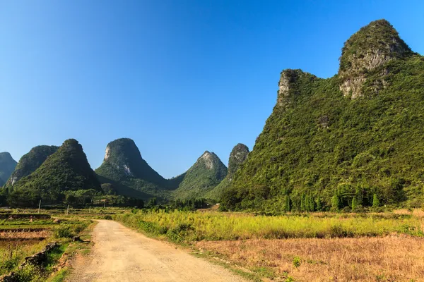 Sand road through a valley with limestone rocks — Stock Photo, Image