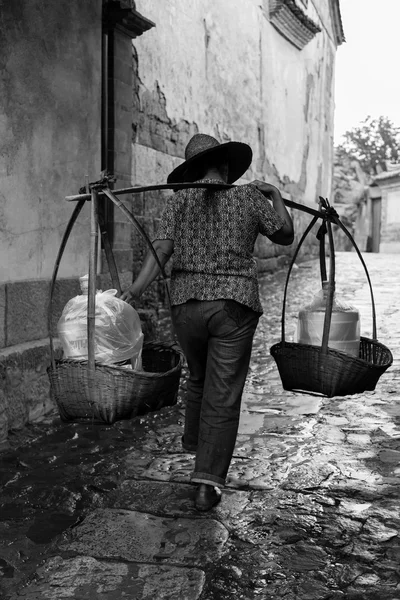 Mujer caminando con una cesta en el cuello —  Fotos de Stock