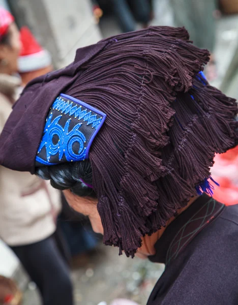 Donna con un tradizionale cappello tribale cinese — Foto Stock