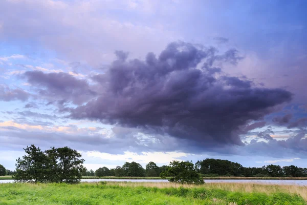 Paesaggio di campagna con un fiume che scorre attraverso — Foto Stock