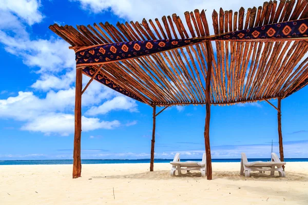 ベッドと白い砂のビーチの傘 — ストック写真