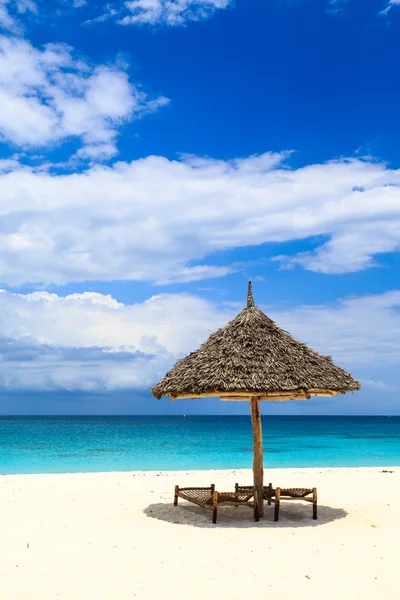 Lits et parasol sur une plage de sable blanc — Photo