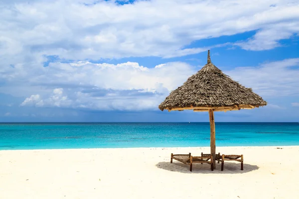 ベッドと白い砂のビーチの傘 — ストック写真