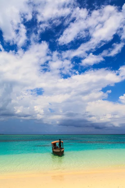 Una barca tradizionale vicino a una spiaggia tropicale — Foto Stock