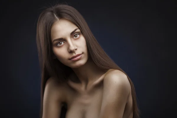 Piękna kobieta z długimi włosami na ciemnym tle — Zdjęcie stockowe