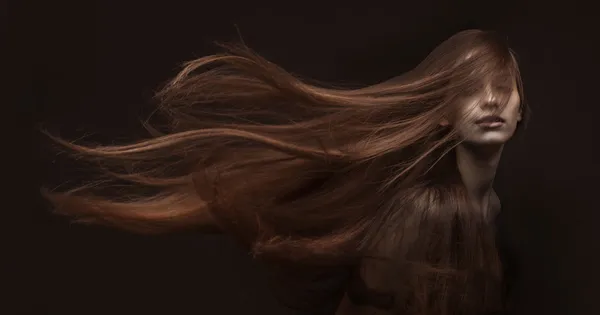 Mulher bonita com cabelos longos no fundo escuro — Fotografia de Stock