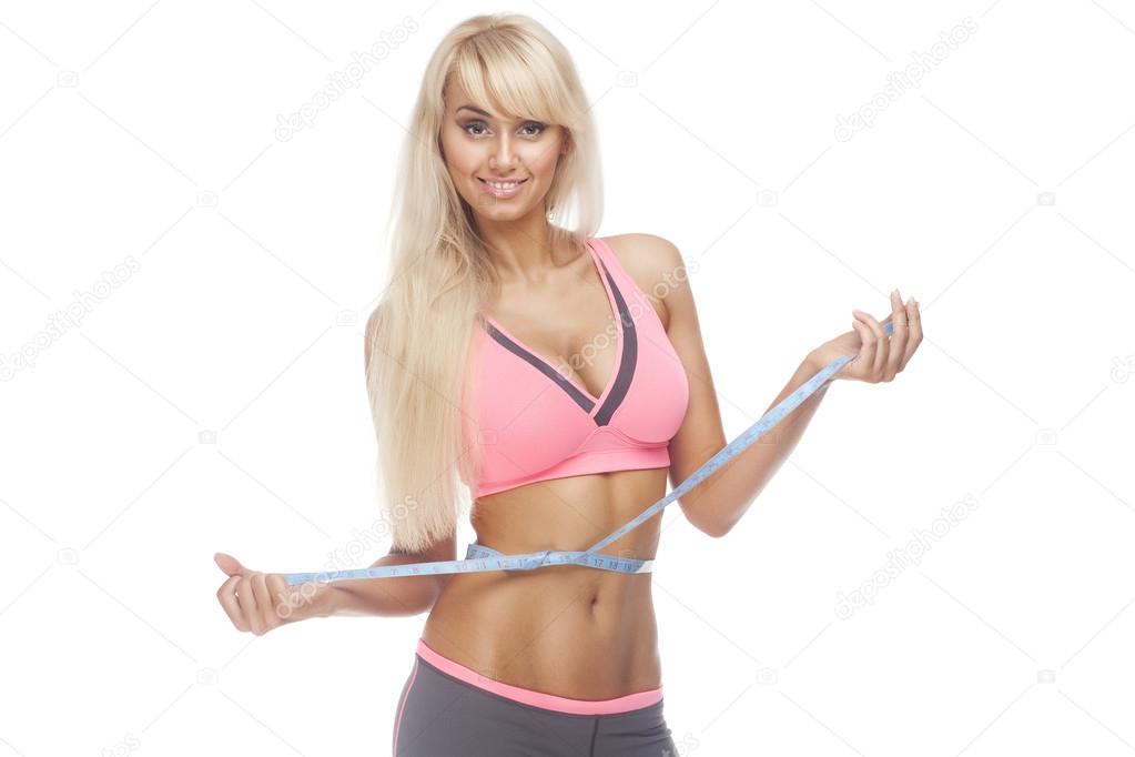 Woman with a big smile measuring her waist