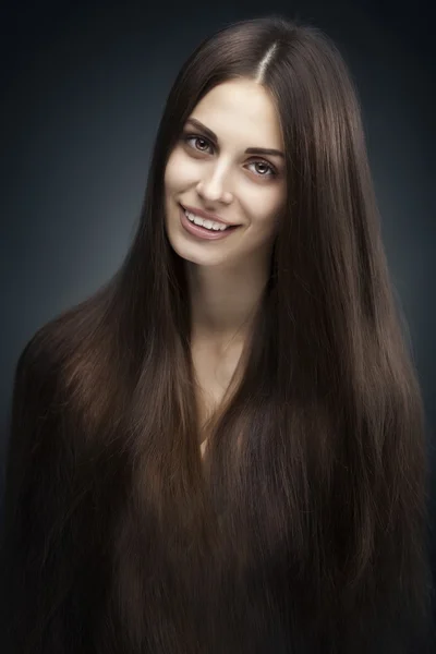 Mulher bonita com cabelos longos no fundo escuro — Fotografia de Stock