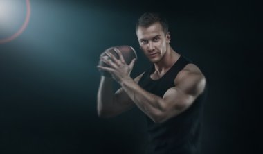 Futbol topu tutan mutlu kas genç adam