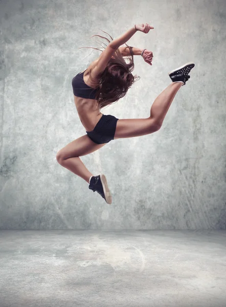 Jonge vrouw danser met grunge muur achtergrond — Stockfoto