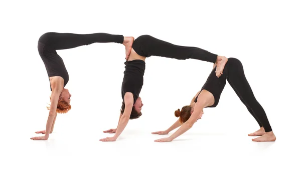 Две женщины и один мужчина практикуют йогу — стоковое фото