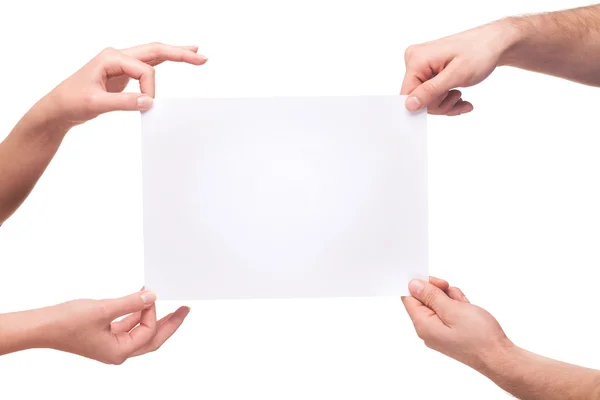 Four hands holding a blank white board — Stockfoto