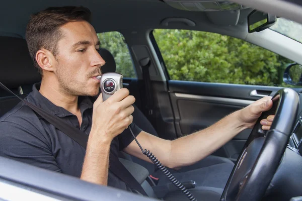 Man blowing into breathalyzer — Stock Photo, Image