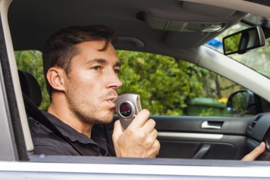 Man blowing into breathalyzer clipart