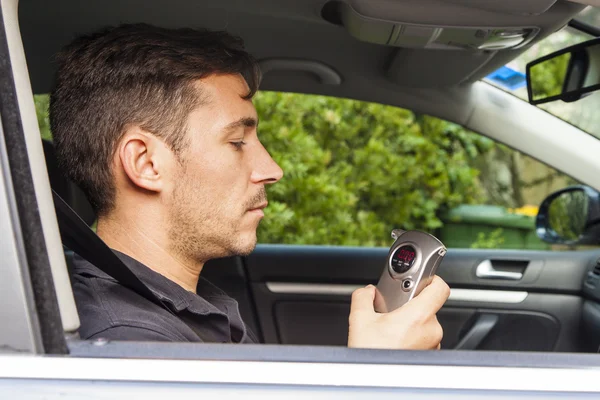 Man looking at breathalyzer — Stock Photo, Image