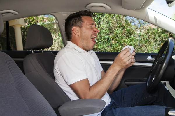 Hombre estornudando en coche — Foto de Stock