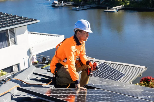 阳光充足时 太阳能电池板技术员在房顶上安装太阳能电池板 — 图库照片