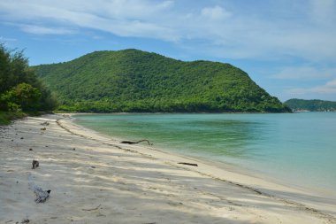 Chonburi Tayland 'ın Sattahip bölgesindeki dağlarla çevrili Koh Samae San Adası' nın beyaz kumlu açık deniz suyu.