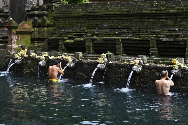 Gli indù balinesi fanno un bagno sacro nel tempio Tirta Empul a Bali - Indonesia — Foto Stock
