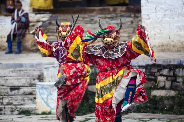 Ченці танцюють у костюми під час фестивалю tsechu ура в bumthang долині в Бутані Ліцензійні Стокові Зображення