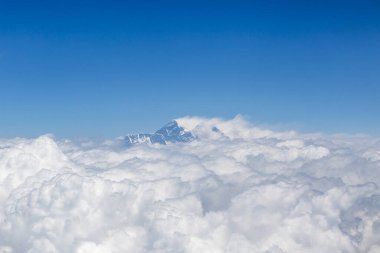 Himalayalar 'ın dağlarına ve bulutların üstündeki Everst Dağı' nın tepesine bakın, Nepal 'deki bir uçaktan görülüyor.