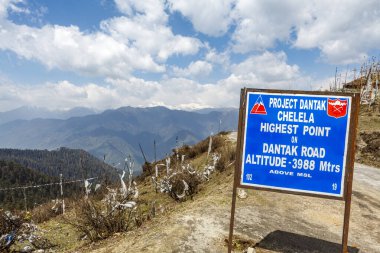 Chelela 'nın en yüksek noktasının işareti ve Asya' nın Butan kentindeki Himalaya dağlarına bakan kar manzarası.