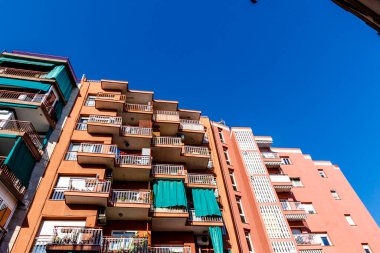 Barcelona, Katalonya, İspanya ve Avrupa 'da mavi gökyüzüne karşı balkonları olan bir apartmanın dışı.