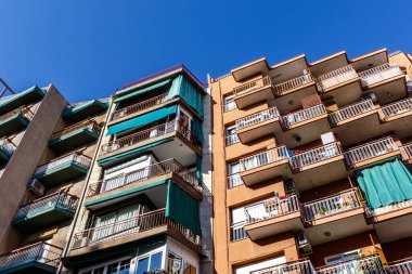 Barcelona, Katalonya, İspanya ve Avrupa 'da mavi gökyüzüne karşı balkonları olan bir apartmanın dışı.