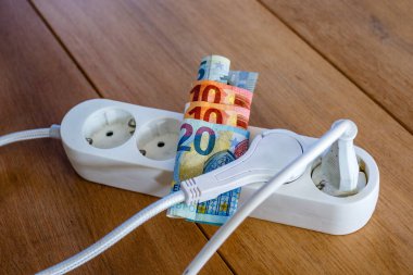 Elektrik prizleri ve Avro banknotları ile elektrik ve günlük yaşam harcamalarının artışını gösteren elektrik bandı