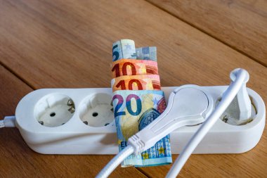 Elektrik prizleri ve Avro banknotları ile elektrik ve günlük yaşam harcamalarının artışını gösteren elektrik bandı