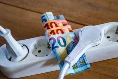 Elektrik prizleri ve Avro banknotları ile elektrik ve günlük yaşam harcamalarının artışını gösteren elektrik bandı