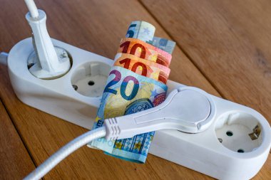 Elektrik prizleri ve Avro banknotları ile elektrik ve günlük yaşam harcamalarının artışını gösteren elektrik bandı