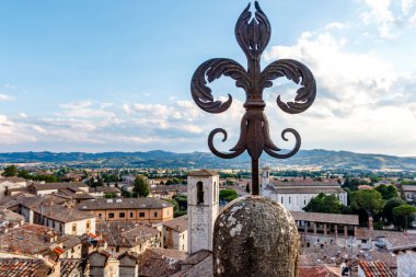 Vintage fleur-de-lys made of cast iron and the old center of Gubbio in the background, Umbria, Italy, Europe