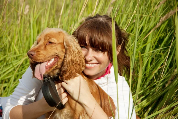 Jovem feliz abraçando seu cão — Fotografia de Stock