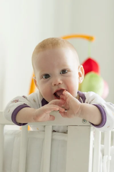 Curious baby boy peeking out of his crib — Stock Photo, Image