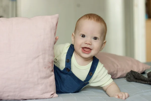 Menino curioso surpreendente enquanto brincava com travesseiros — Fotografia de Stock