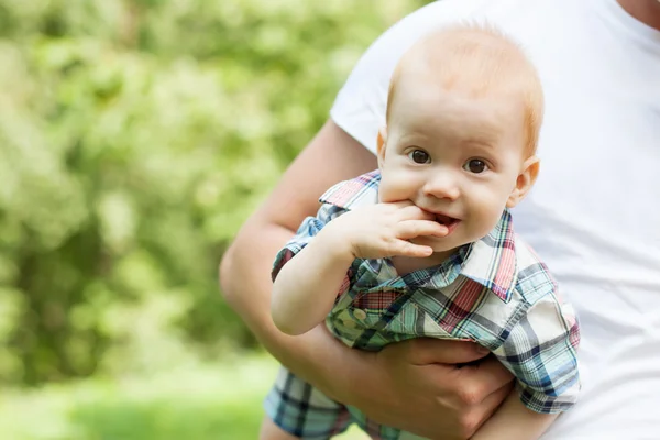 Sorrindo bebê bonito nas mãos do pai — Fotografia de Stock