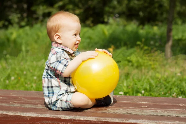Дитина грає з жовтим м'ячем — стокове фото