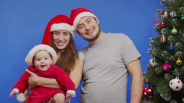 Noel ağacının yanında gülümseyen mutlu bir aile Selfie ya da Yeni Yıl Aile Tatilleri ve Video Mesajı Çekiyor.