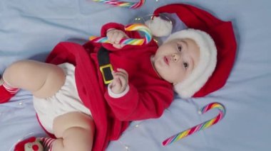 Noel Baba şapkası ve elbisesi giymiş, yeni doğmuş şirin bir bebeğin Noel portresi..