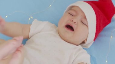 Noel Baba şapkası takan, ağlayan, yeni doğmuş bir bebeğin Noel portresi..
