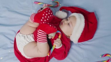 Noel Baba şapkası ve elbisesi giymiş, yeni doğmuş şirin bir bebeğin Noel portresi.