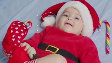 Noel Baba şapkası ve elbisesi giymiş, yeni doğmuş şirin bir bebeğin Noel portresi..