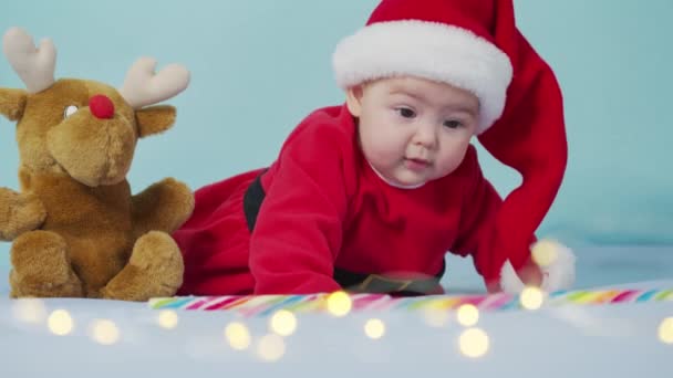 Kerst portret van schattige kleine pasgeboren baby meisje, het dragen van santa hoed en jurk, winter tijd. — Stockvideo